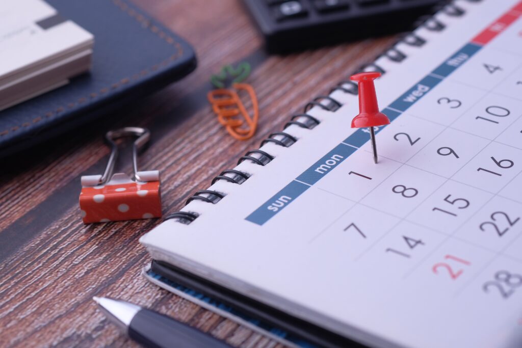 A calendar and other stationery on top of a table.