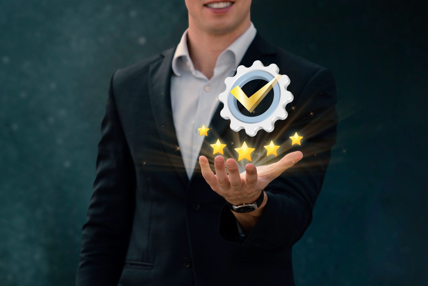 A businessman holds a gear wheel with stars on it.
