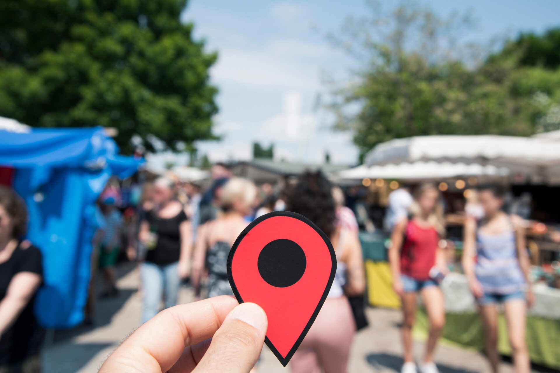 A person holding a red pin with a map, pinpointing a location.