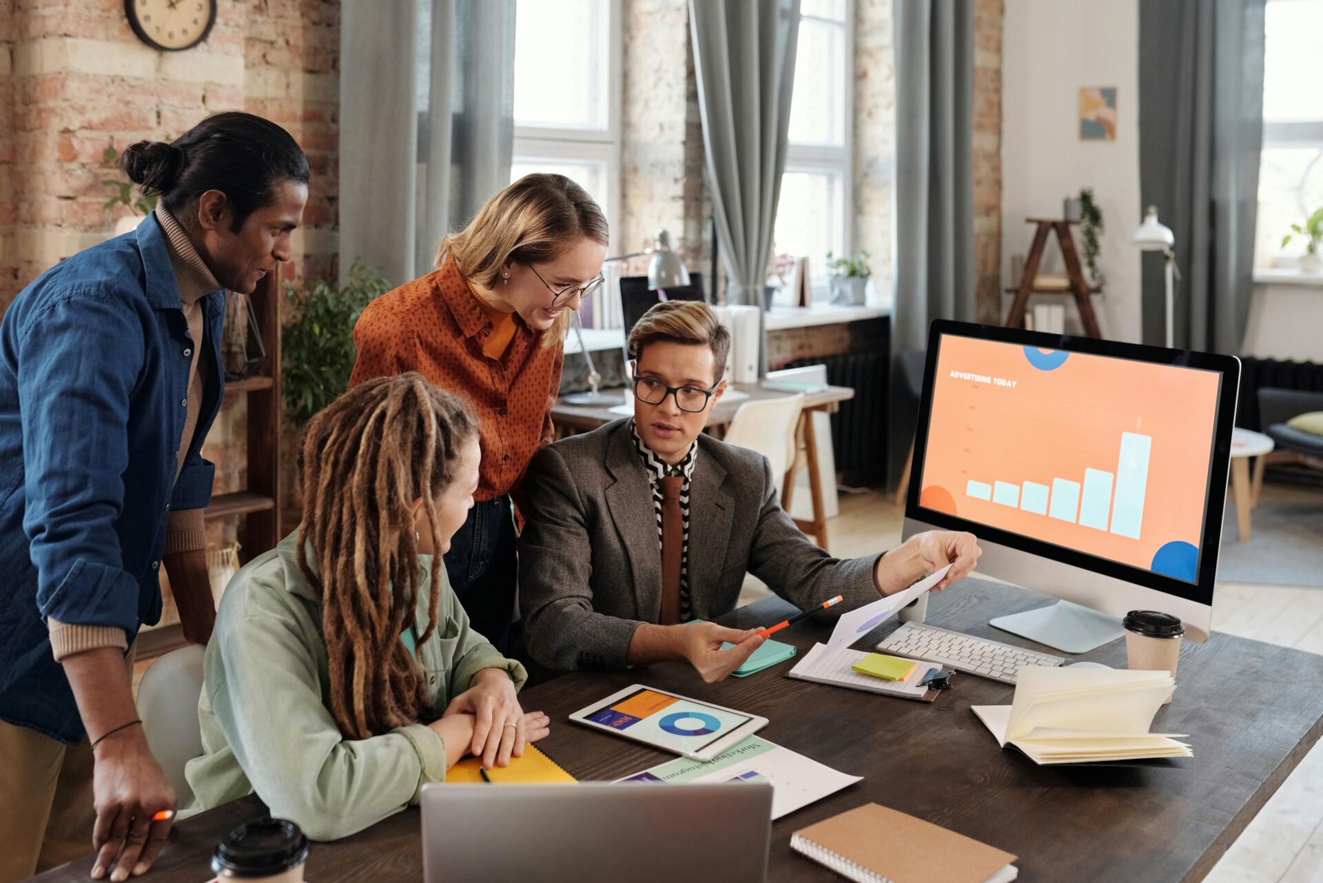 A diverse team collaborating on marketing projects in a modern office setting.