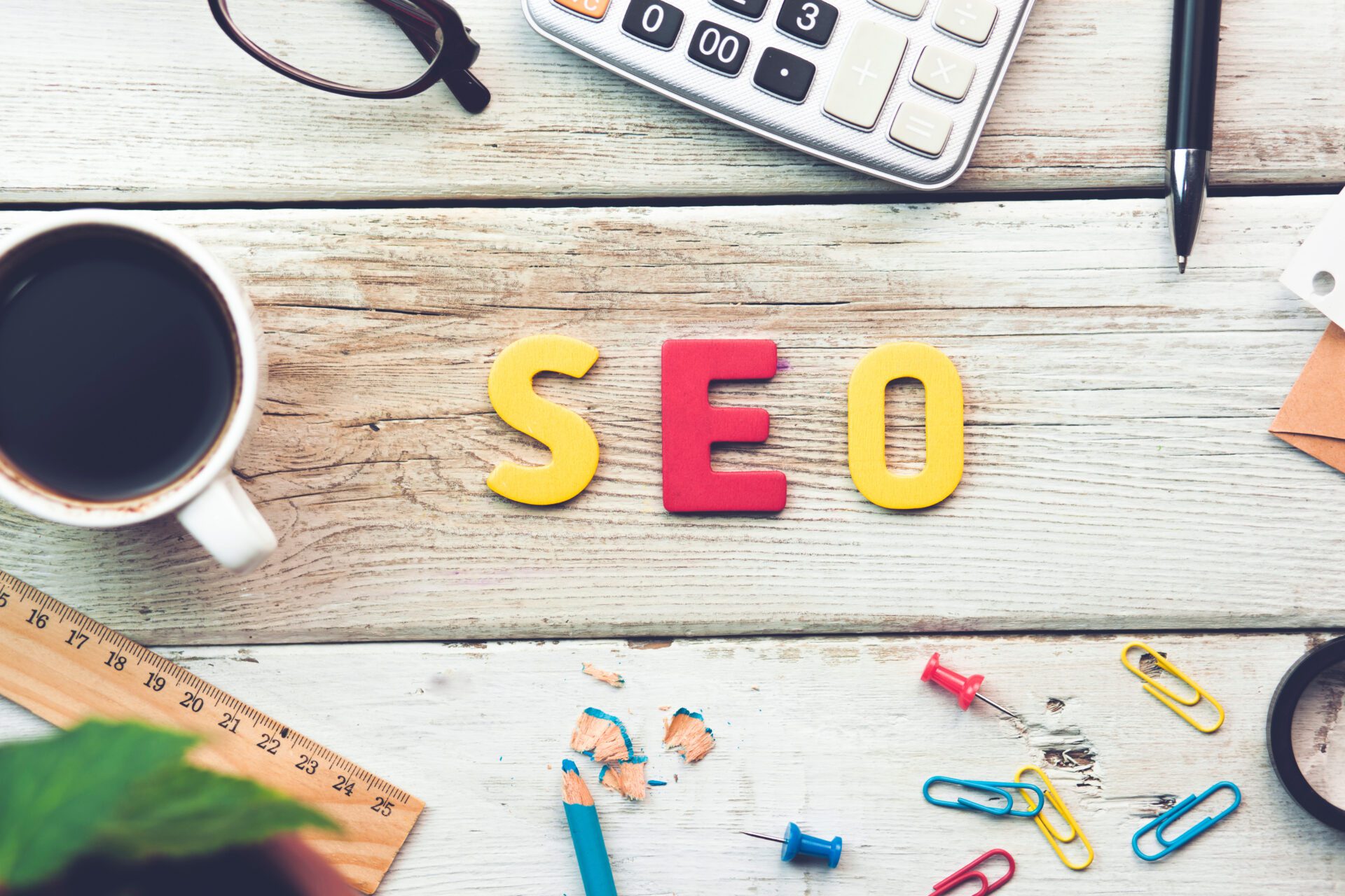 The word SEO is assembled on a wooden work desk